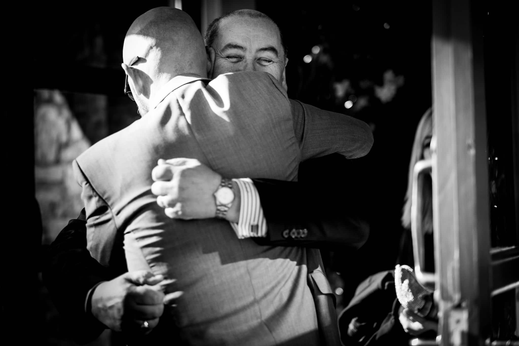 guest hugs the groom 
