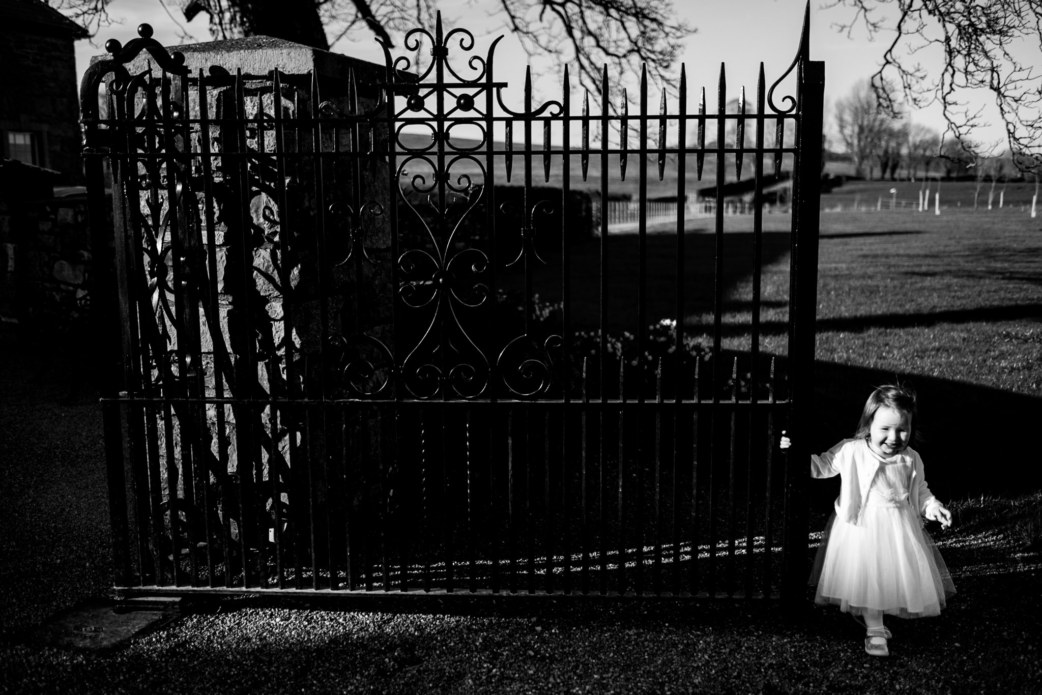 flower girl stands beside a gate