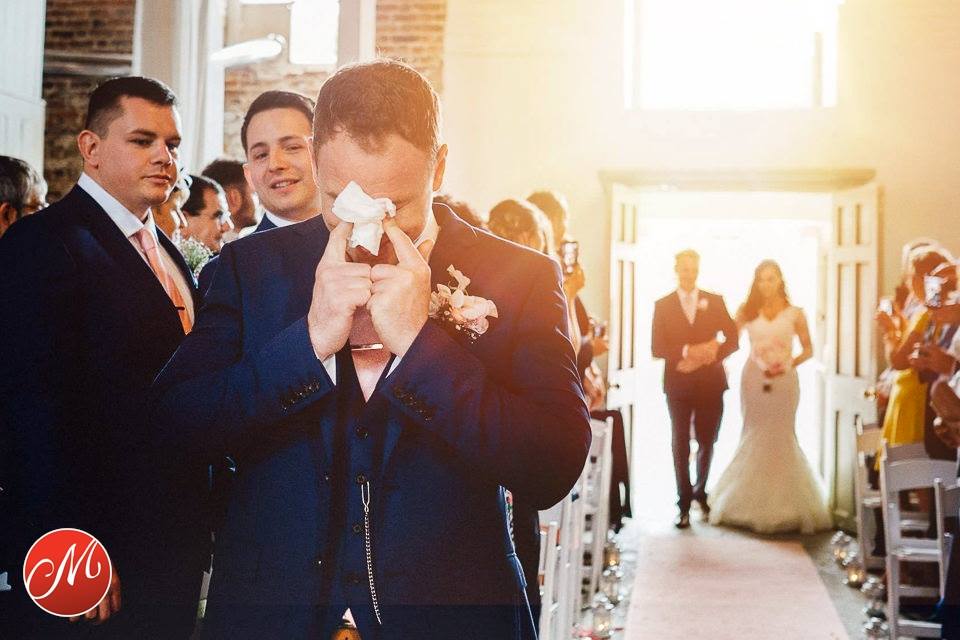 A teary eyed groom awaits his bride at The Millhouse