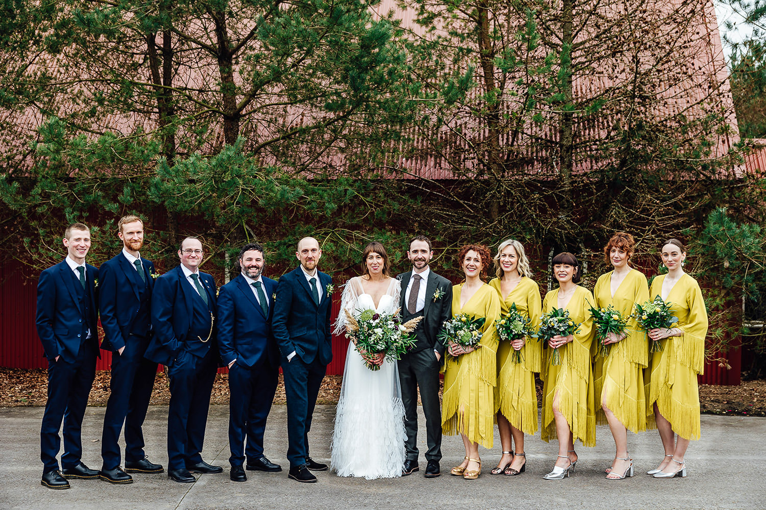 A bridal party pose after the ceremony at a tin church at Mount Druid