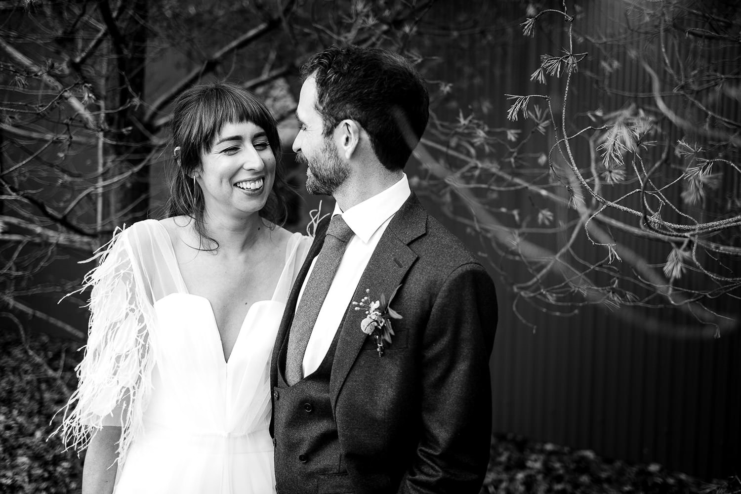 A bridal and groom embrace pose after the ceremony at a tin church at Mount Druid